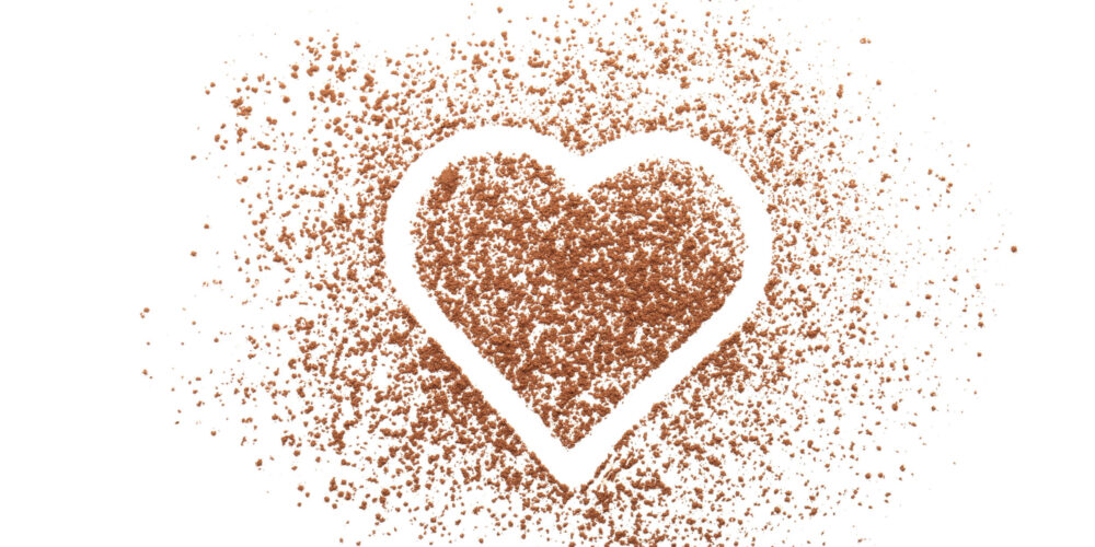 Heart composition with cocoa powder on white background